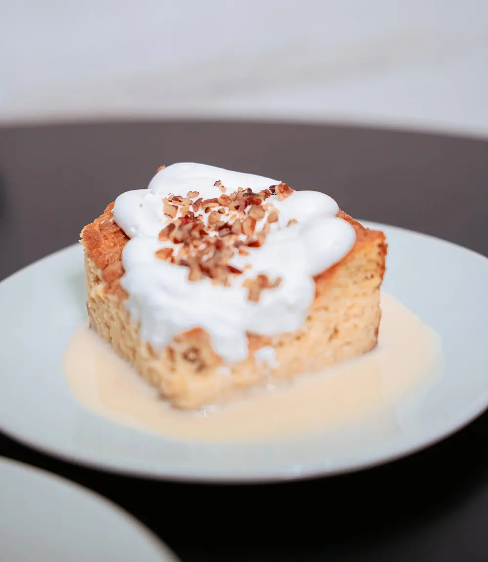 Una rebanada de pastel con crema y nuez picada, de Local Café